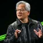 Tech executive speaking on stage at AI keynote event with blue lighting