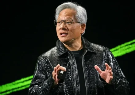 Tech executive speaking on stage at AI keynote event with blue lighting