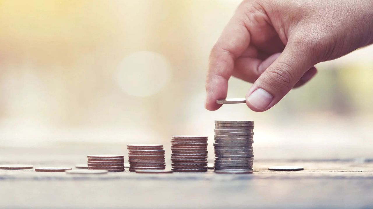 Hand stacking coins in rising levels to represent a CD ladder and growing short-term savings