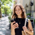 A consumer reviewing a bank statement on a smartphone showing checking account deposit balance and fee adjustments