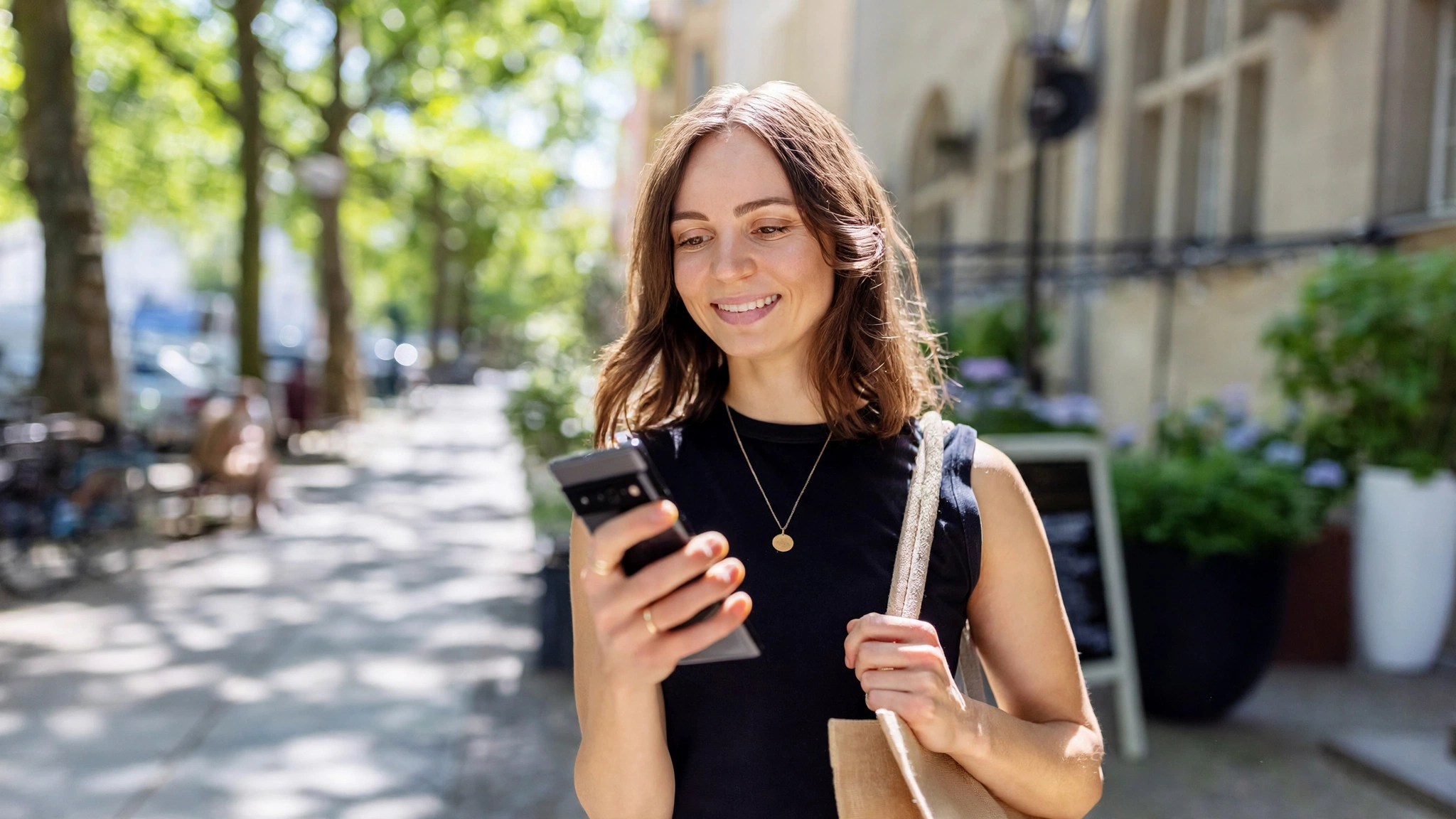 A consumer reviewing a bank statement on a smartphone showing checking account deposit balance and fee adjustments